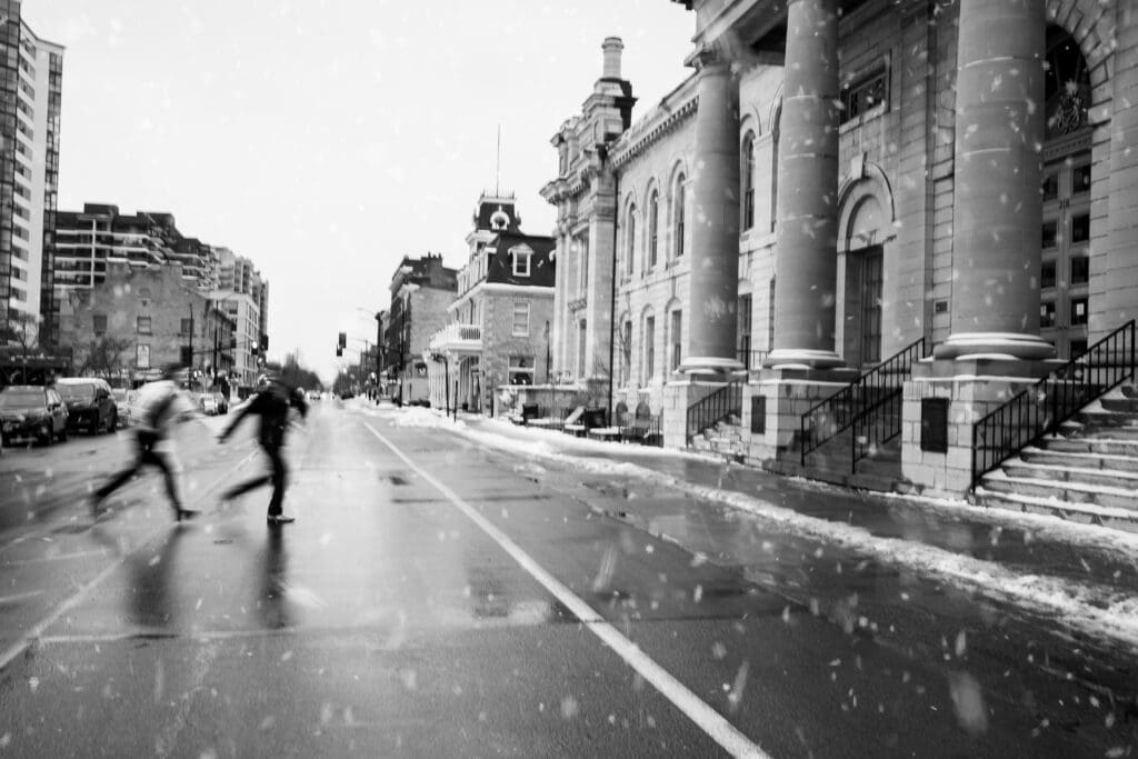 A Kingston, Ontario couple running across the street in the snow.
