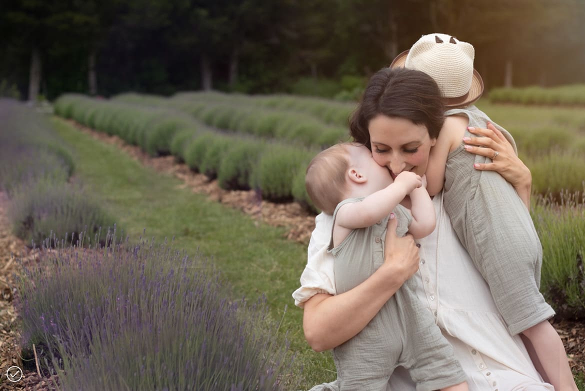A mom hugging her two toddlers