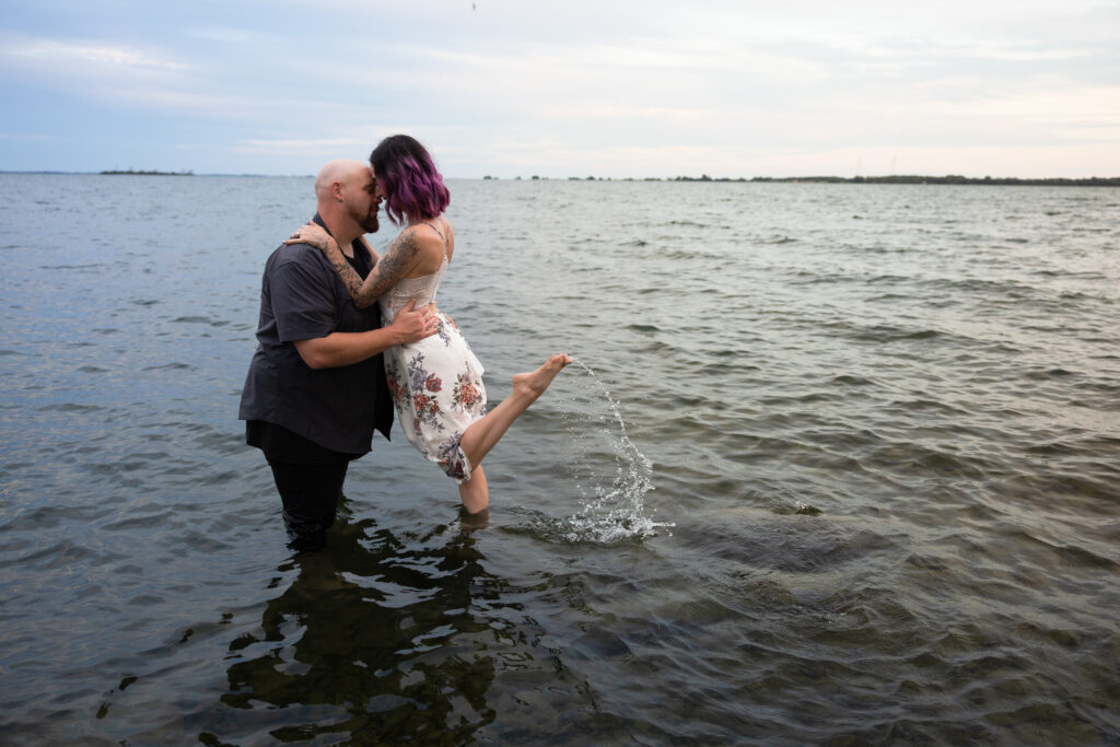 woman kicking up her foot in the water while an arc of water drips off